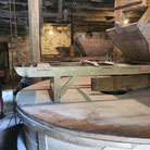 Intérieur du moulin avec son énorme meule qui écrase de grain pour le transformer en farine