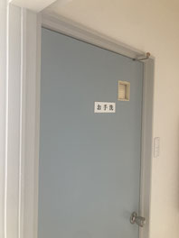 落ち着いた水色で塗装されたトイレドア