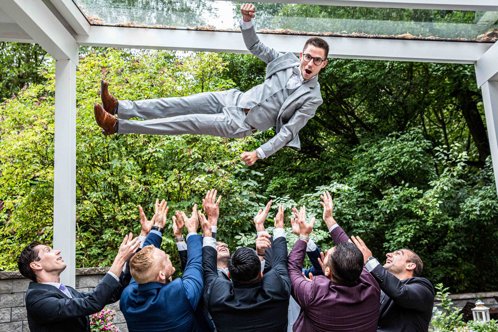 Hochzeitsfotograf, Steffens Herrenmühle - Herrenmühle 4, 3755 Alzenau, Hochzeitsreportage, Hochzeitsfotos, Hochzeitspaar, Fliegender Bräutigam, Bräutigam hochwerfen, geiles Gruppenbild, lustige Gruppenbilder, amüsante Gruppenfotos für Hochzeiten