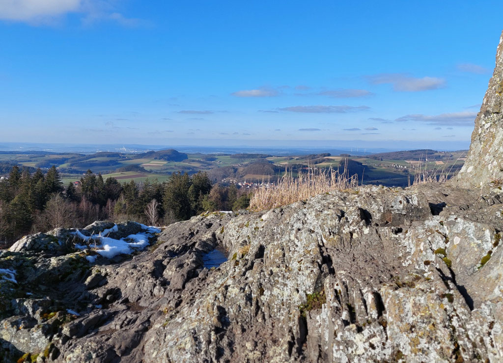 Blick von der Kuppe eines steiniges Gipfels über die Berg-Landschaft der Rhön bei Gersfeld