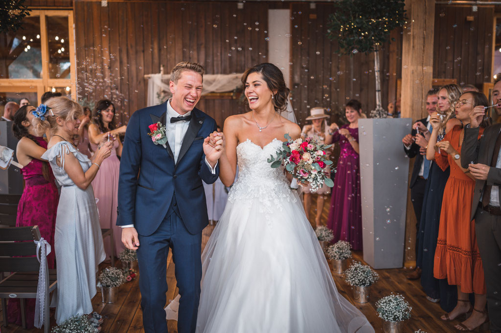 fröhliches Hochzeitspaar beim Auszug nach der freien Trauung