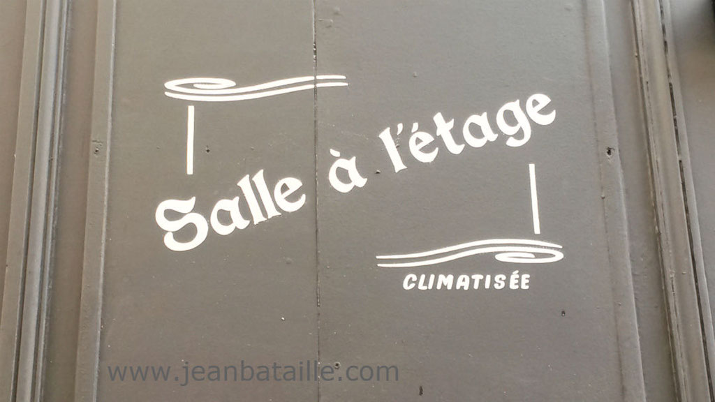 Lettres peintes en acrylique sur devanture magasin en bois