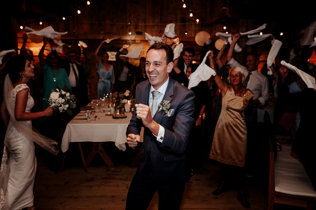 Der Bräutigam tanzt jubelnd. Hochzeitsreportage am Schliersee. Hochzeitsfotograf Schliersee.