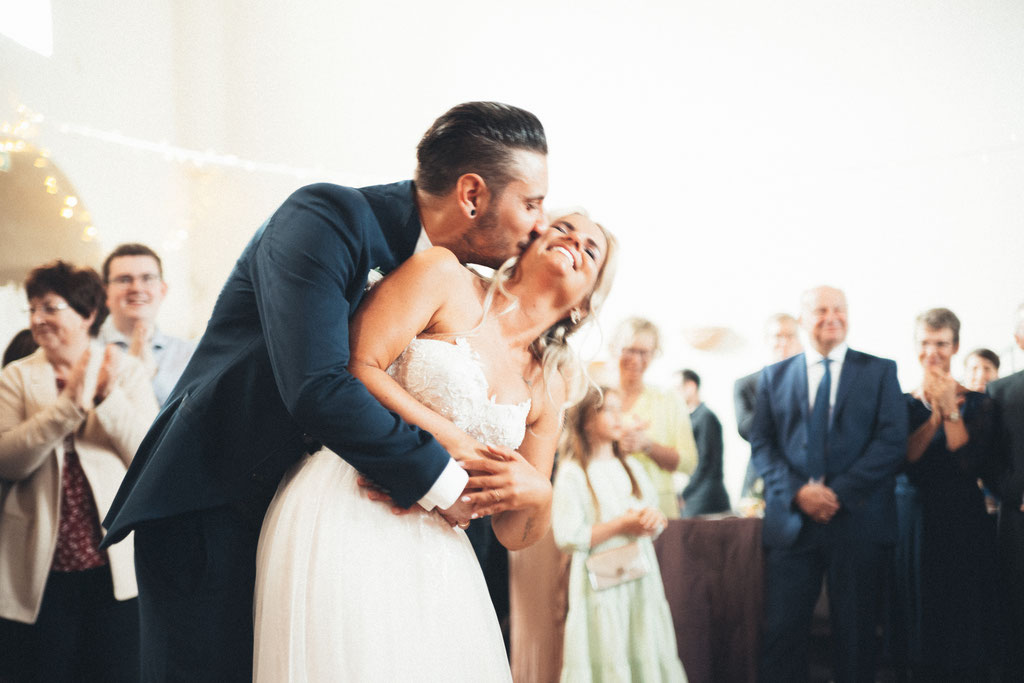 Schnappschuss von Braut und Bräutigam beim Küssen während dem Tanzen.