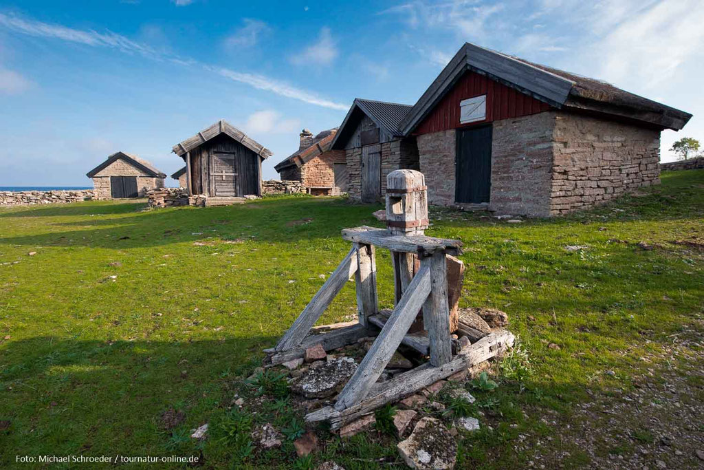 Vor den Hütten stehen Überreste alter Seilwinden.