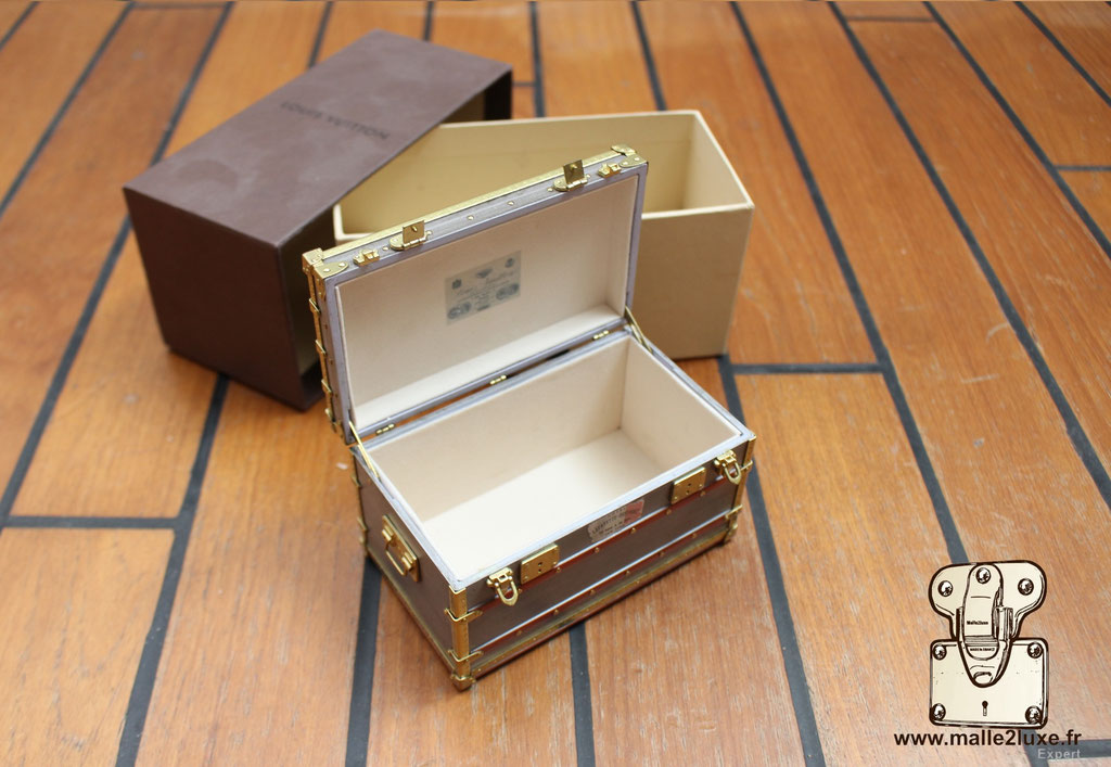 Close-up of Louis Vuitton zinc Explorateur mini trunk, historic 1899 replica with fine craftsmanship details.