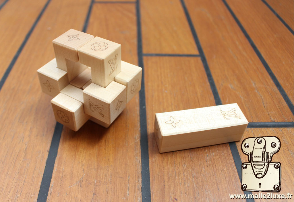 Pateki et histoire Louis Vuitton : Cube symbolique de l’héritage de la Maison et des jeux de voyage.