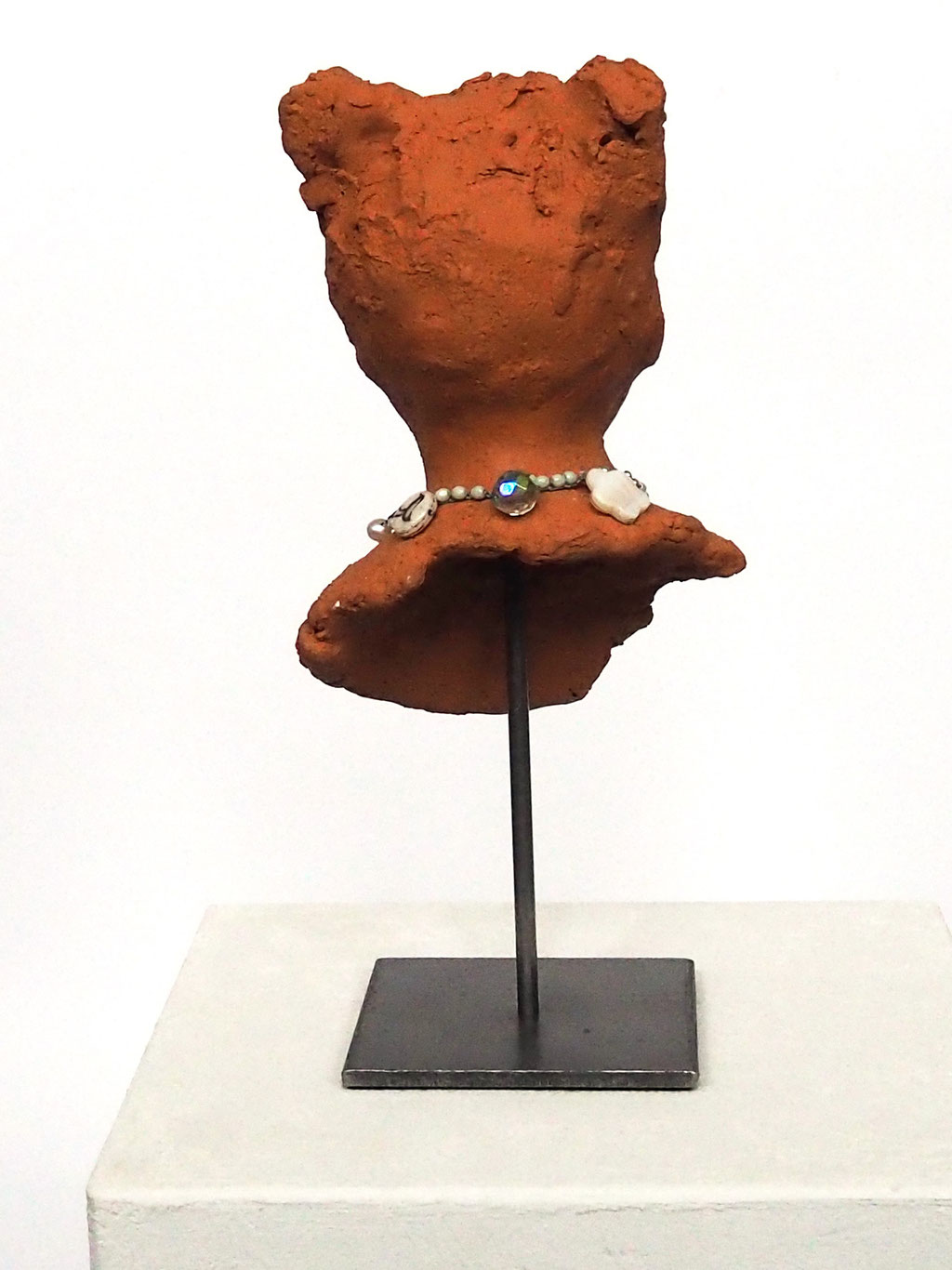 Skulptur Mädchengesicht aus rotem Ton auf Skulpturenständer mit Perlenkette