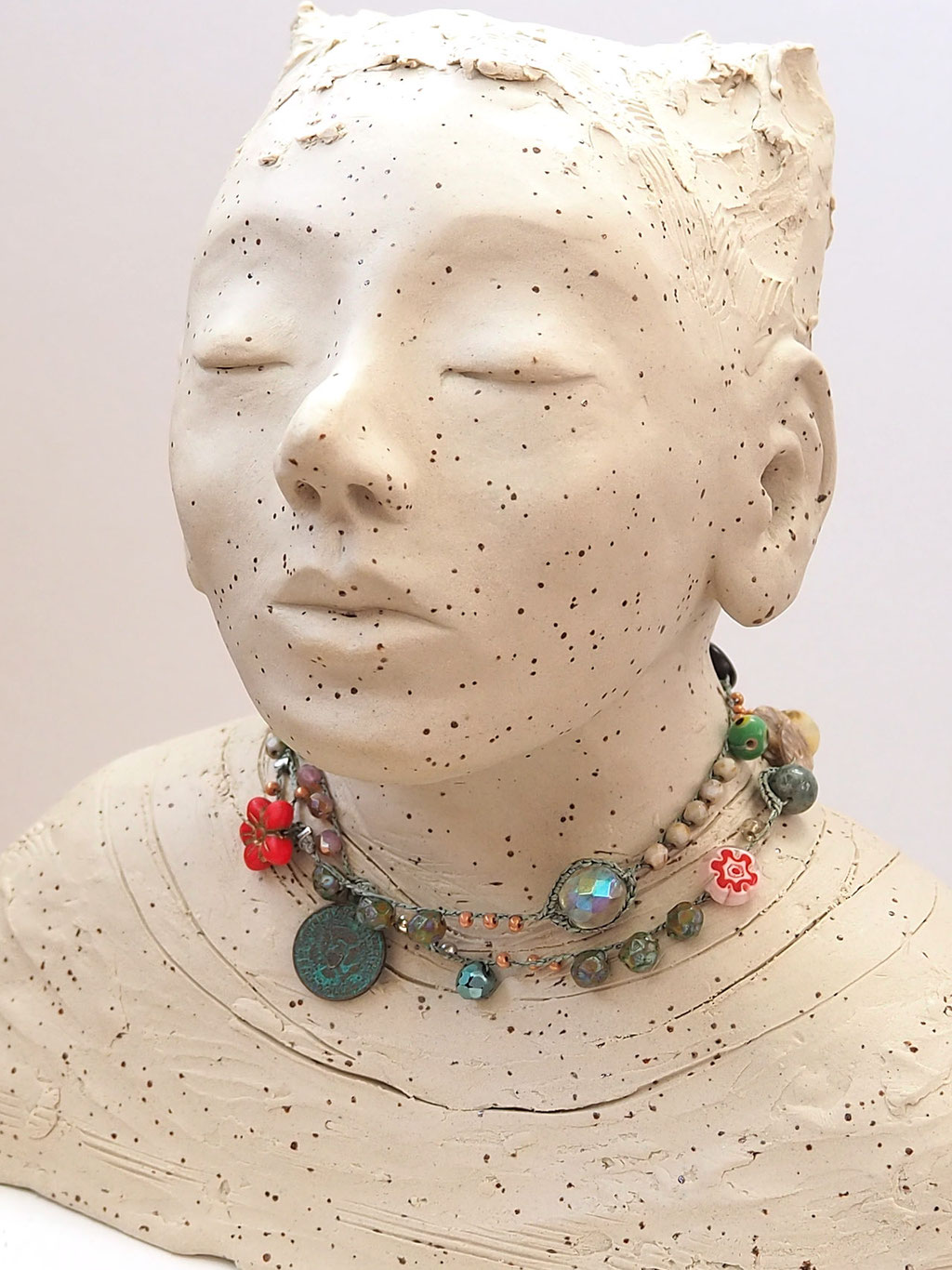 weisser Buddha auf Keramik mit Perlenkette