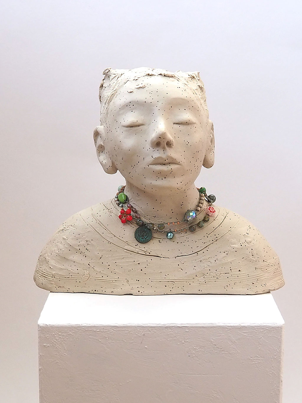 weisser Buddha auf Keramik mit Perlenkette