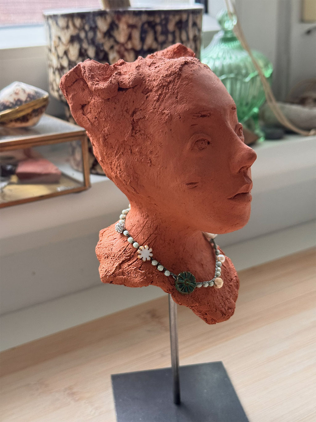 Skulptur Mädchenkopf aus rotem Ton mit Perlenkette auf Skulpturenständer