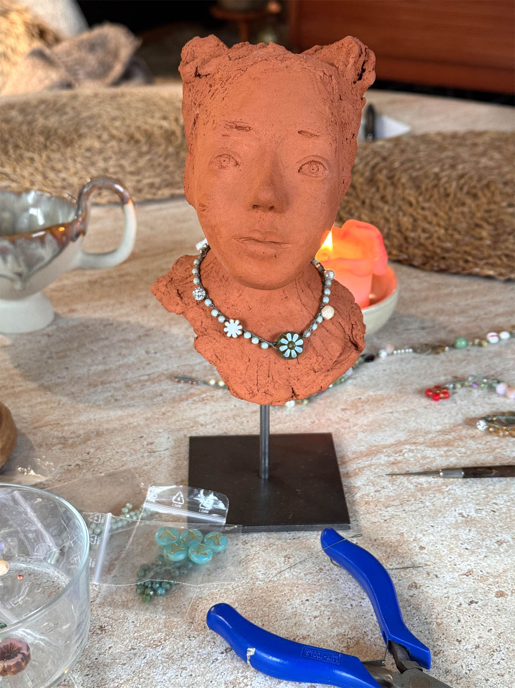 Büste aus rotem Ton mit Perlenkette