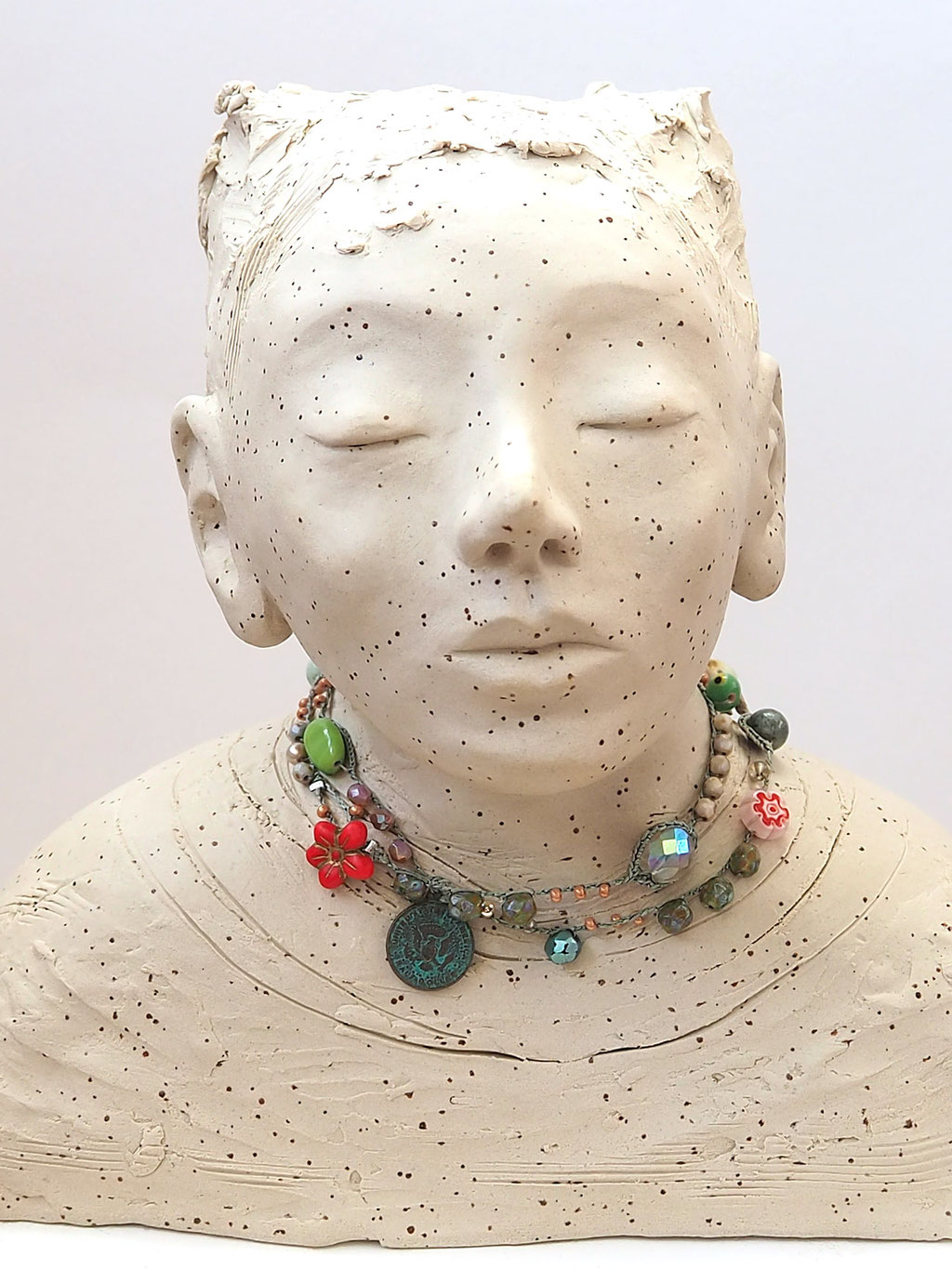 weisser Buddha auf Keramik mit Perlenkette