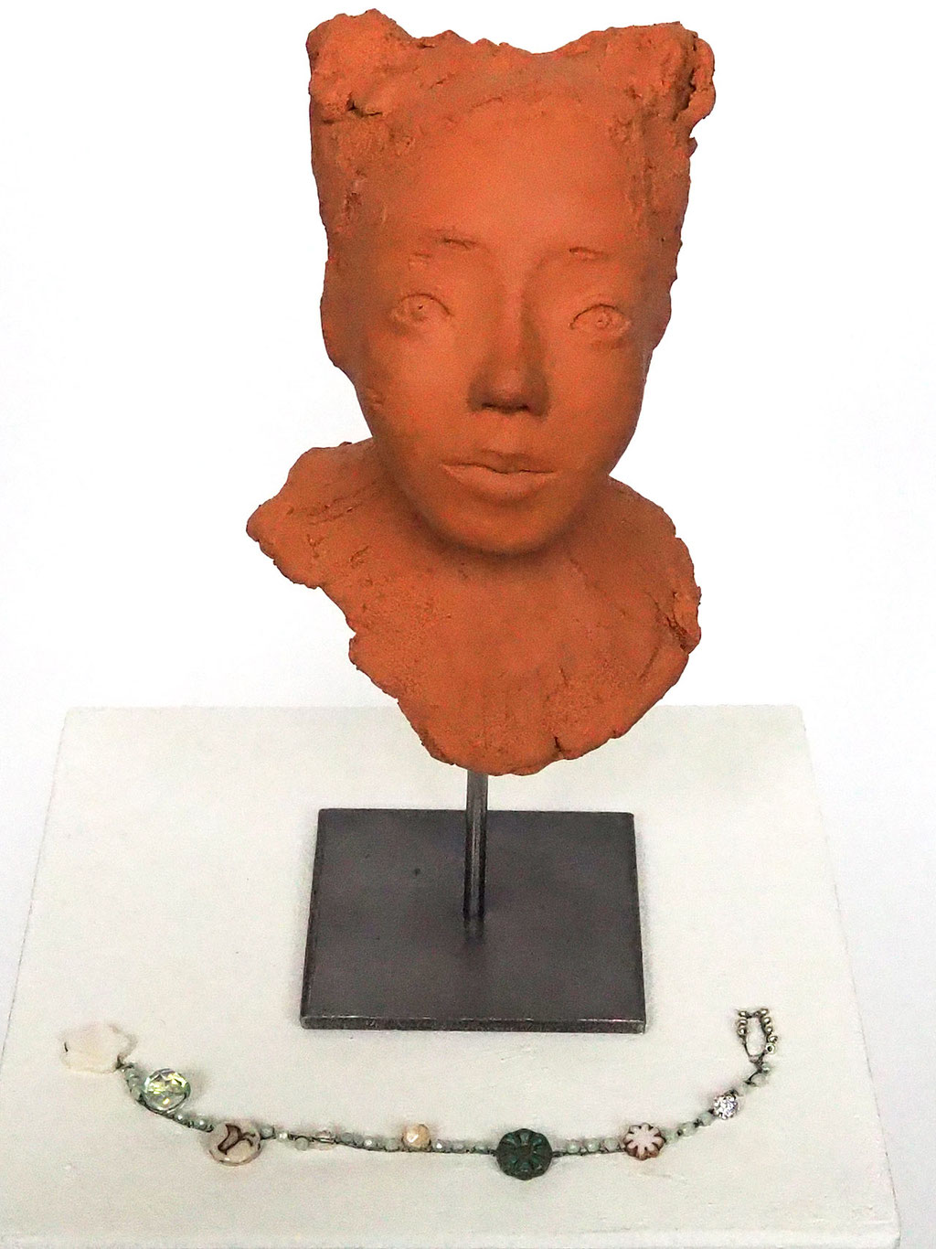 Skulptur Mädchengesicht aus rotem Ton auf Skulpturenständer mit Perlenkette