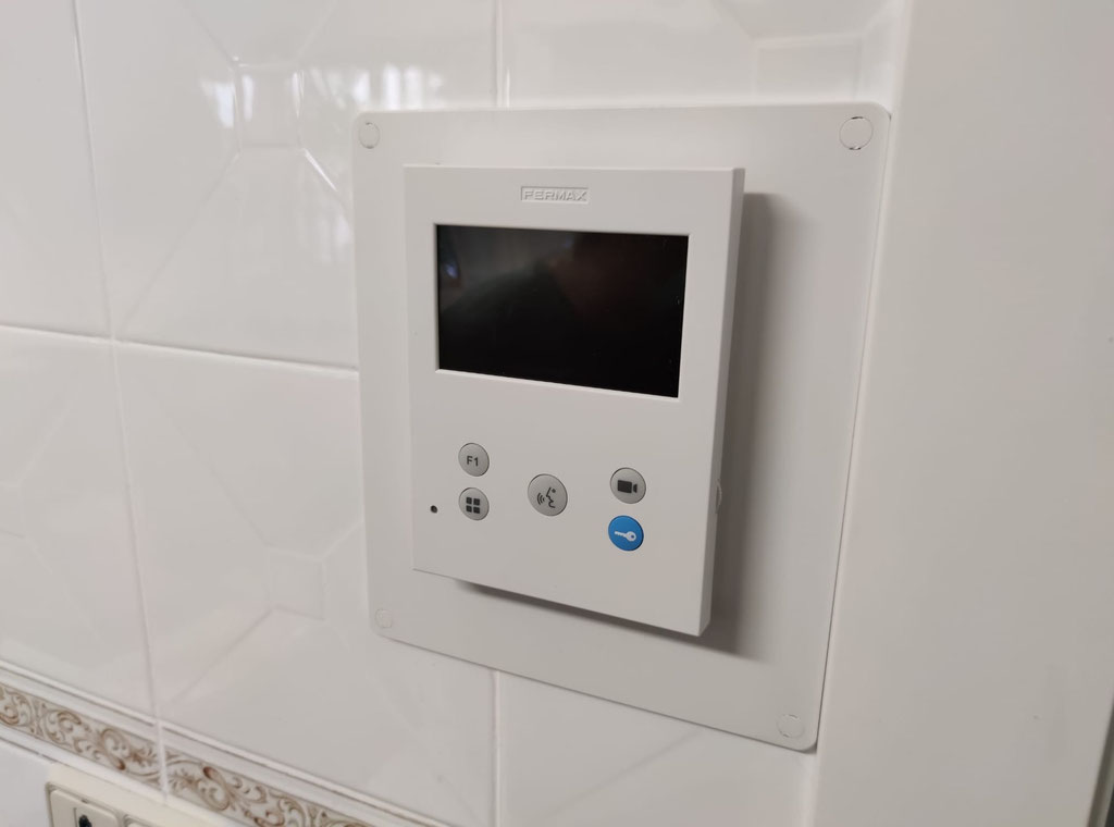 Detalle de monitor VEO DUOX PLUS de Fermax sobre azulejo blanco
