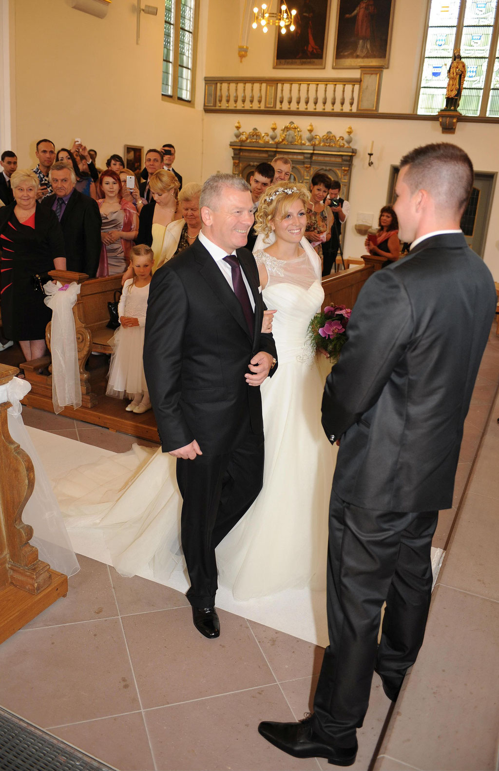 Übergabe der Braut beim Einzug in die Kirche - Fotografin für Hochzeit in Paderborn