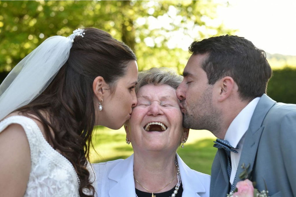 Brautpaar küsst die Oma . Hochzeit auf dem Uphof in Jöllenbeck