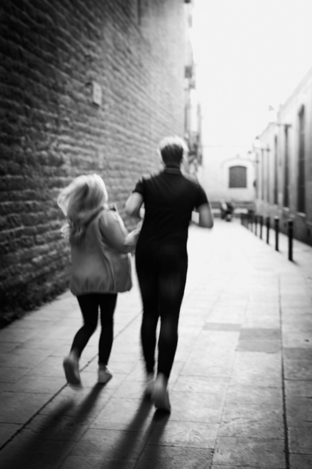 Couplephotographer - Coupleshoot Barcelona, Paar rennt Hand in Hand durch die Straßen Barcelonas
