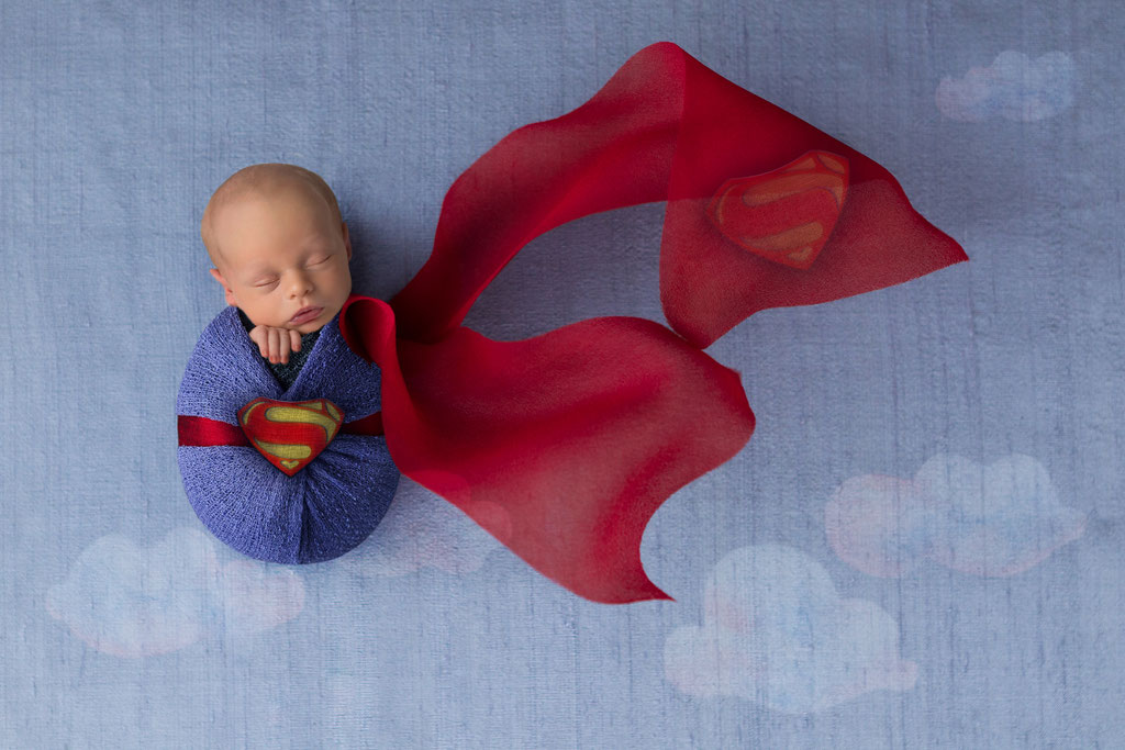 Lustiges Babyfoto als Superman mit digitalem Hintergrund auf blauem Grund im Studio Hamburg