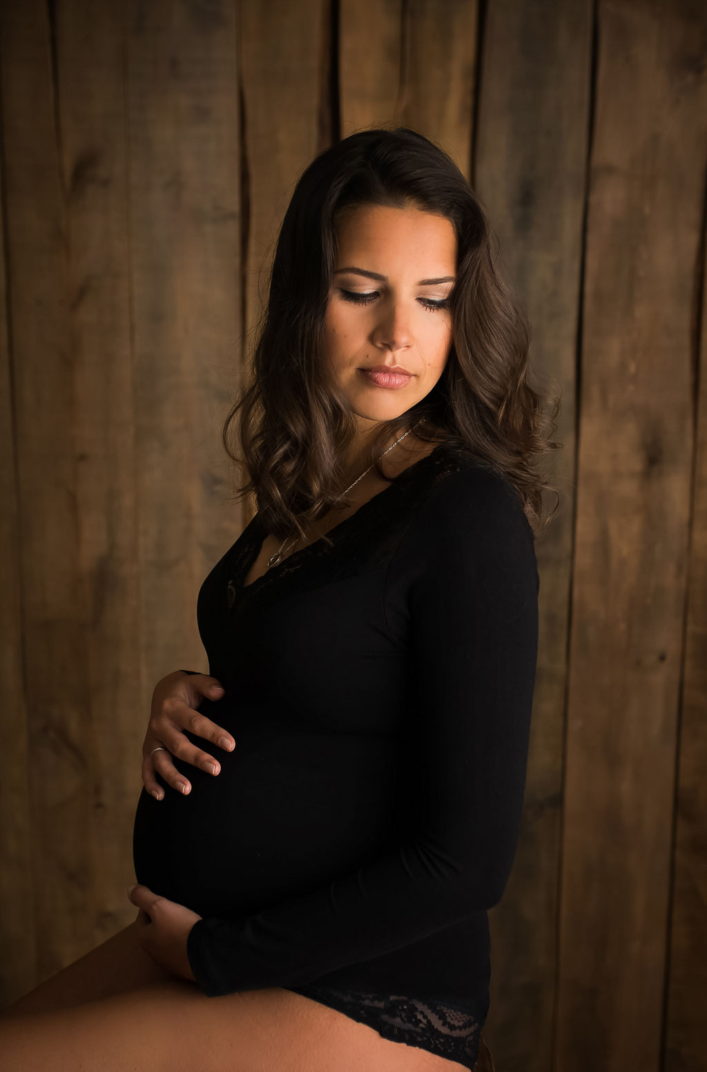 Ästhetischer Fokus auf die Rundung des Babybauchs vor neutralem Hintergrund