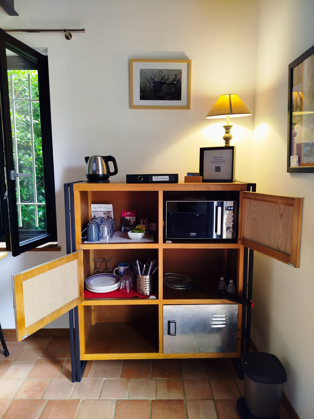Meuble d’appoint équipé : micro-ondes, couverts, jeux de société, raquettes... – Tout est pensé pour un séjour autonome et convivial dans l’Oise.