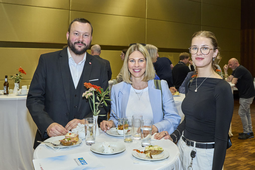 Drei Gäste beim Essen und Plaudern
