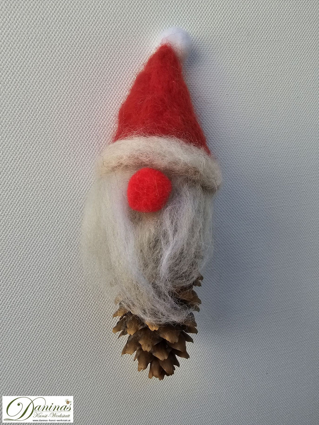 Weihnachtszwerg Rednose. Handgefertigte Märchenfigur aus Fichtenzapfen, mit weißen Haaren und langem Bart aus Wolle, einer rot-weißen nadelgefilzten Wollmütze und einer roten Knopfnase