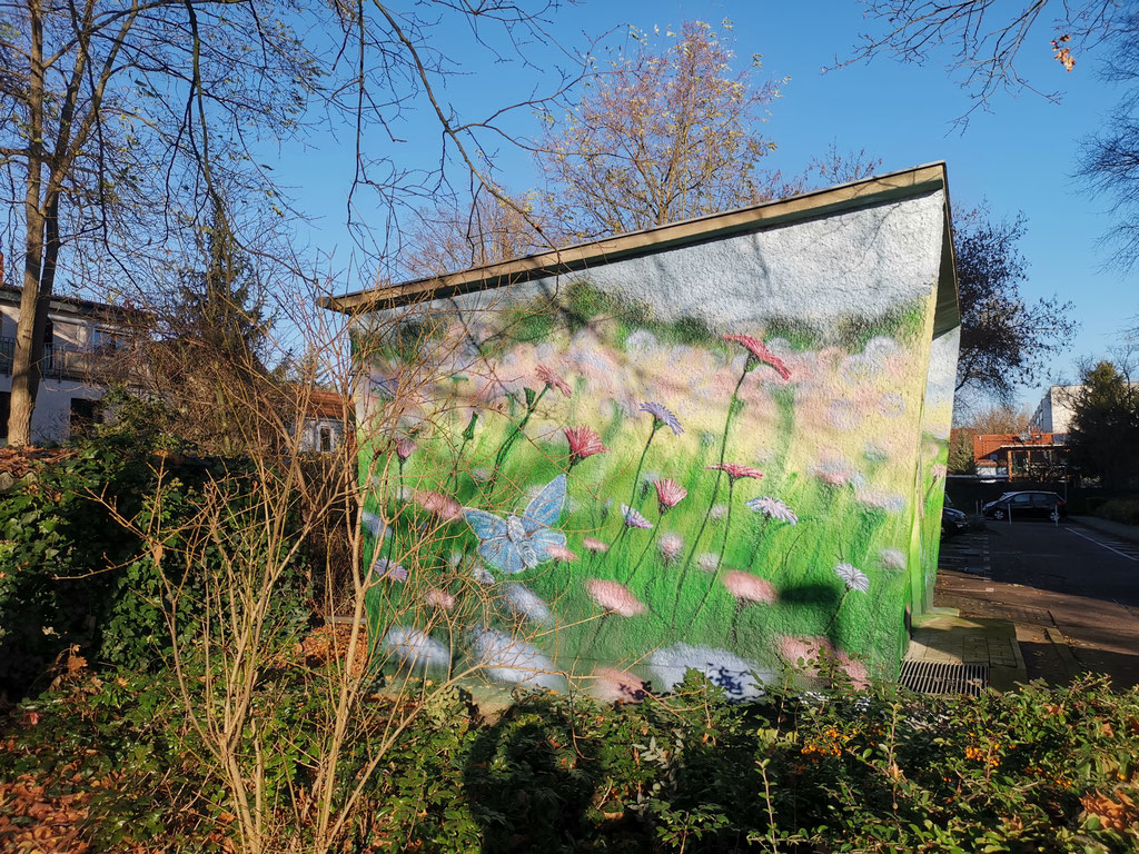 Vom grauen Block zur grünen Oase: Energie trifft Natur in diesem lebendigen Wandbild.