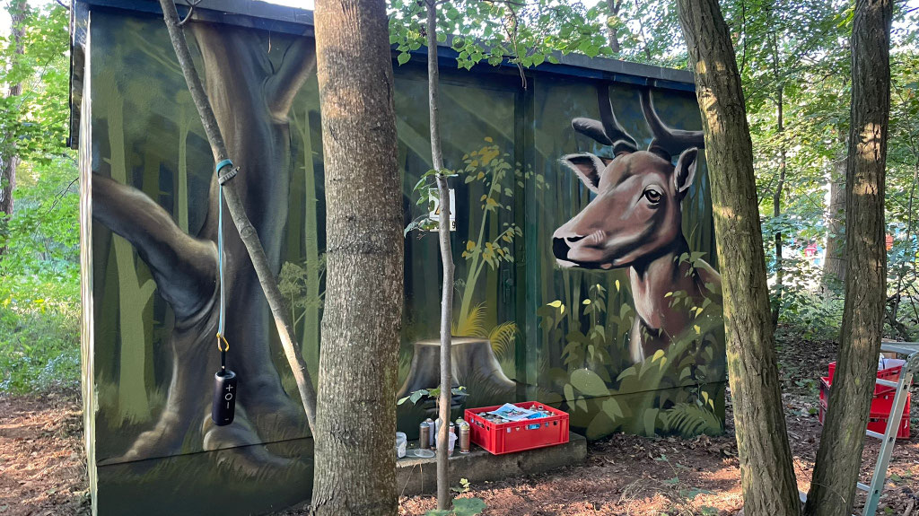 Professionelles Graffiti-Auftragswerk mit Naturmotiven auf Technikgebäude. Ästhetischer Vandalismusschutz für Infrastruktur in ganz Deutschland von Appolloart.