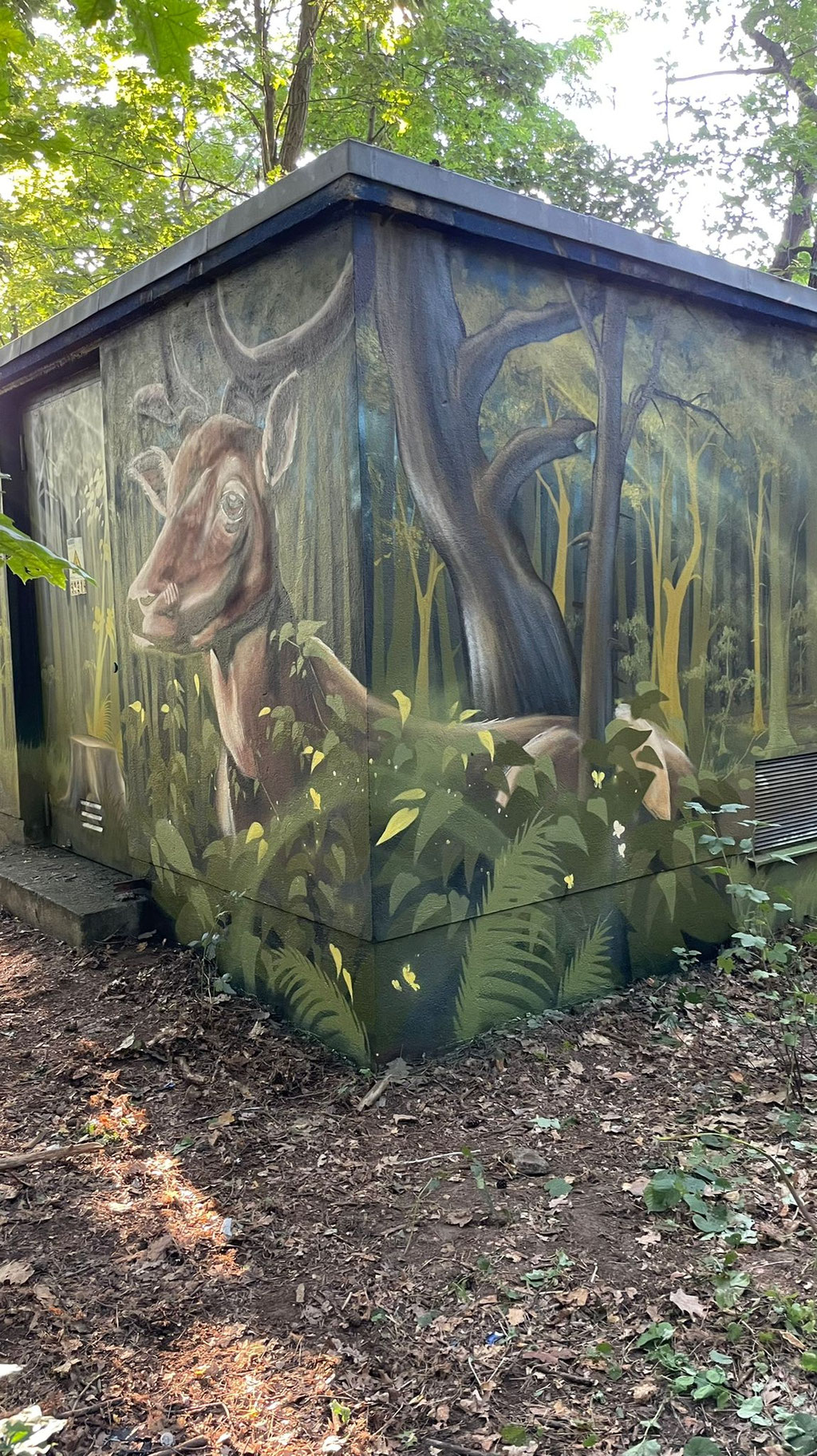 Detailreiche Wandmalerei auf Putz, die ein Reh fotorealistisch in die Umgebung integriert. Hochwertiges Kunsthandwerk für Fassaden, bundesweit verfügbar.