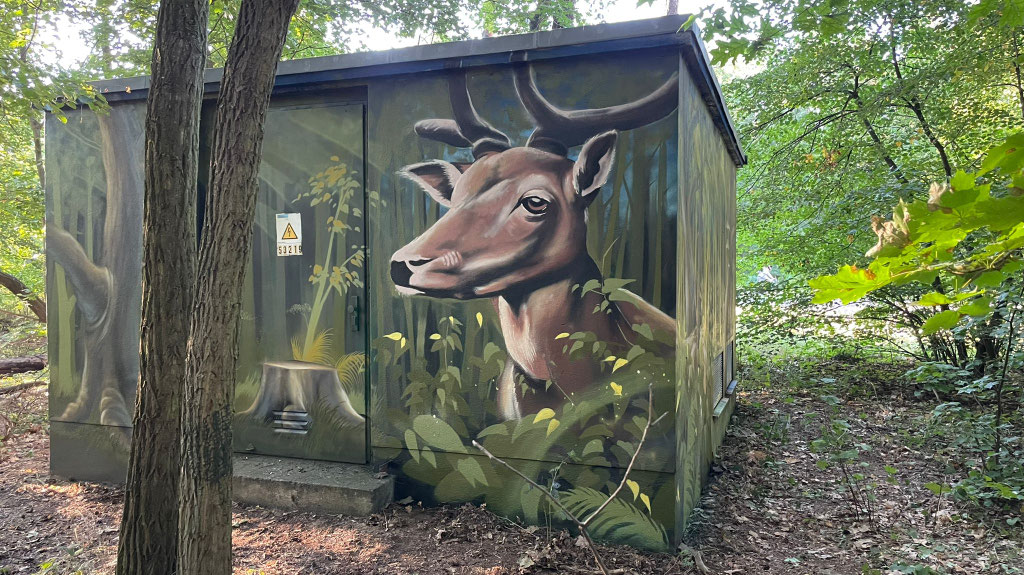 Großformatige Auftragsmalerei am Waldrand. Das fotorealistische Mural ist ein Referenzprojekt für anspruchsvolle Objektgestaltung durch Appolloart, deutschlandweit.