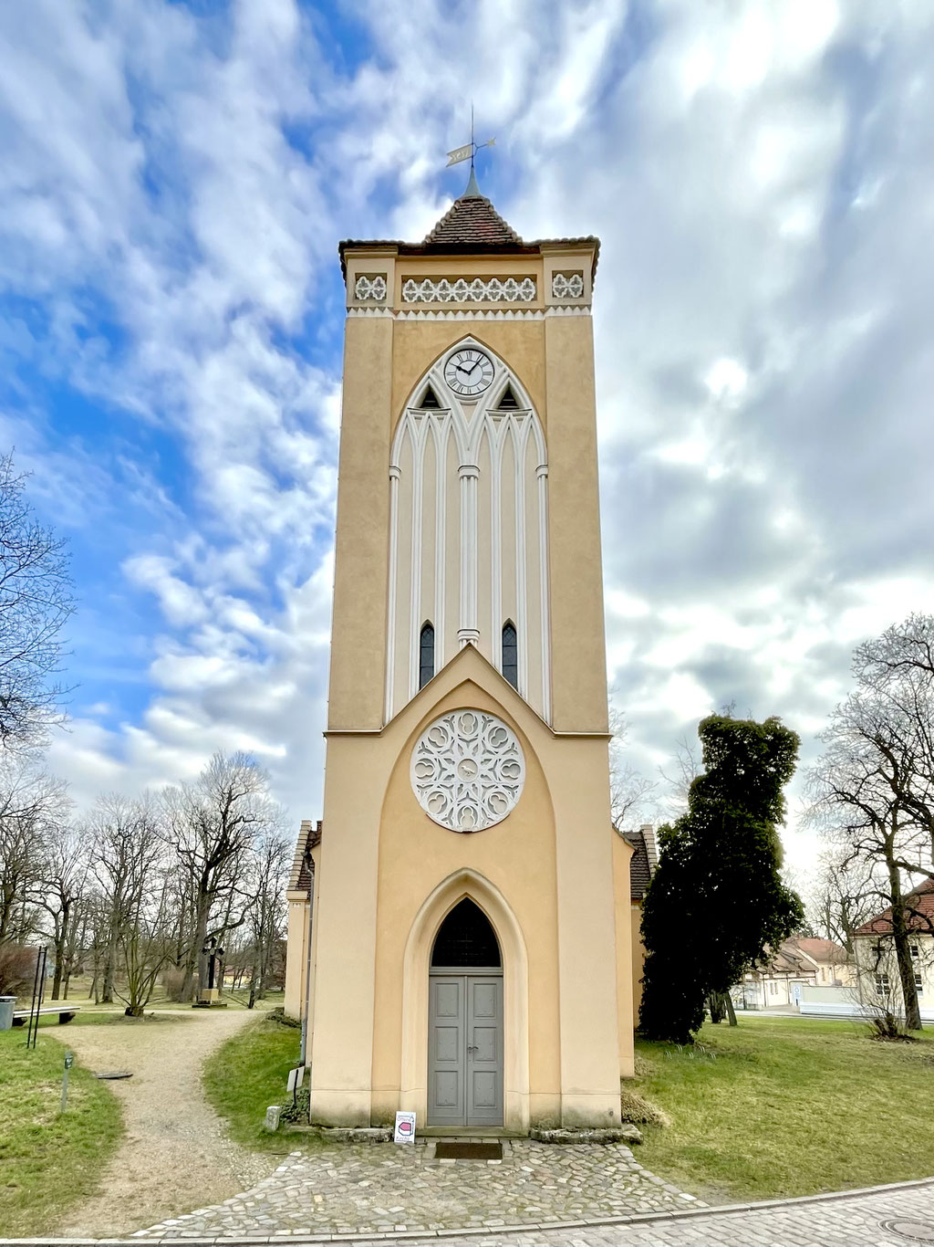 Der querrechteckige Westturm mit spitzbogig gerahmte Haupteingang der Dorfkirche Paretz mit aufstuckiertes Blendmaßwerk.