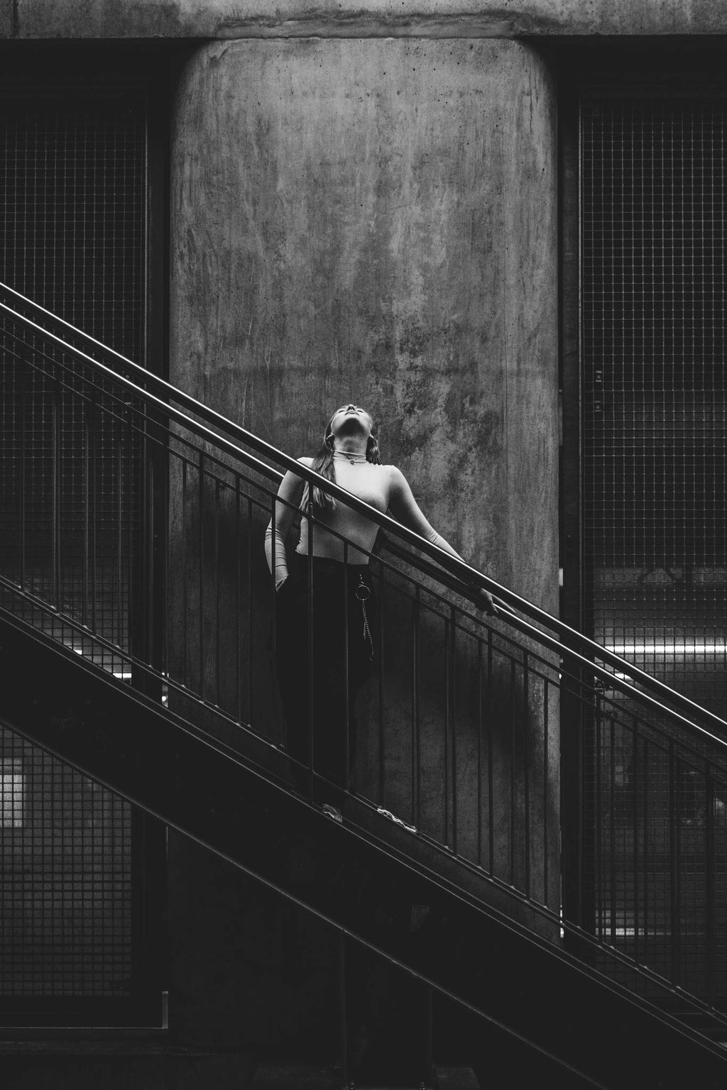 Portrait mit stehendem Model auf Treppe in urbanen Setting in schwarz weiß.