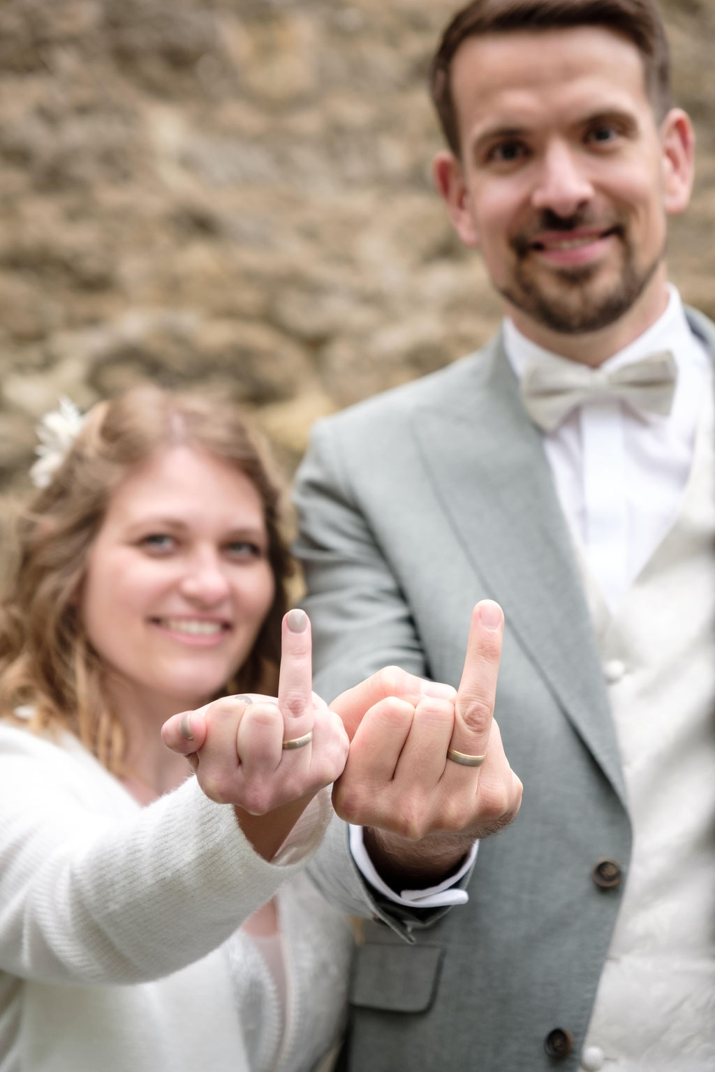 Hochzeitsfoto des Brautpaares beim Präsentieren der Ringe.