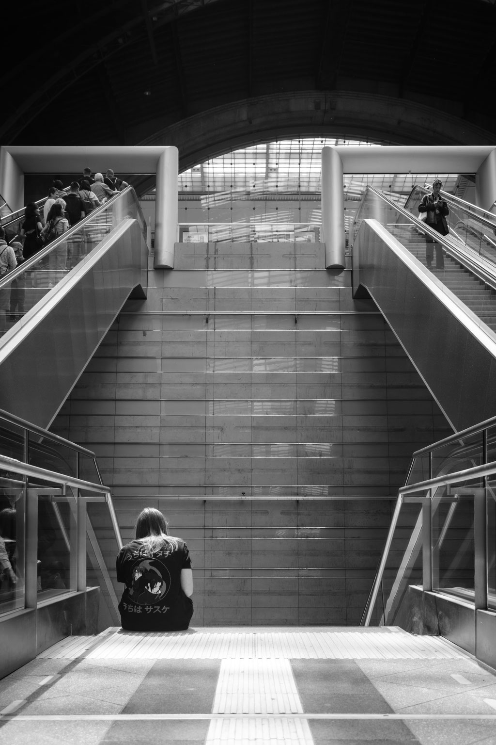 Person sitz vor Treppe im Leipziger Hauptbahnhof.