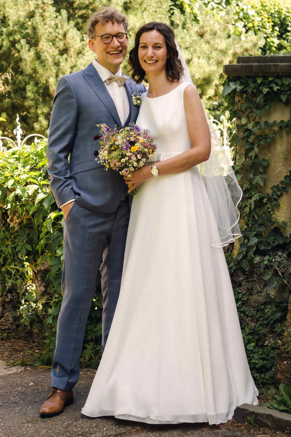 Hochzeitsfotografie des Brautpaares im Park mit Blumenstrauß. 