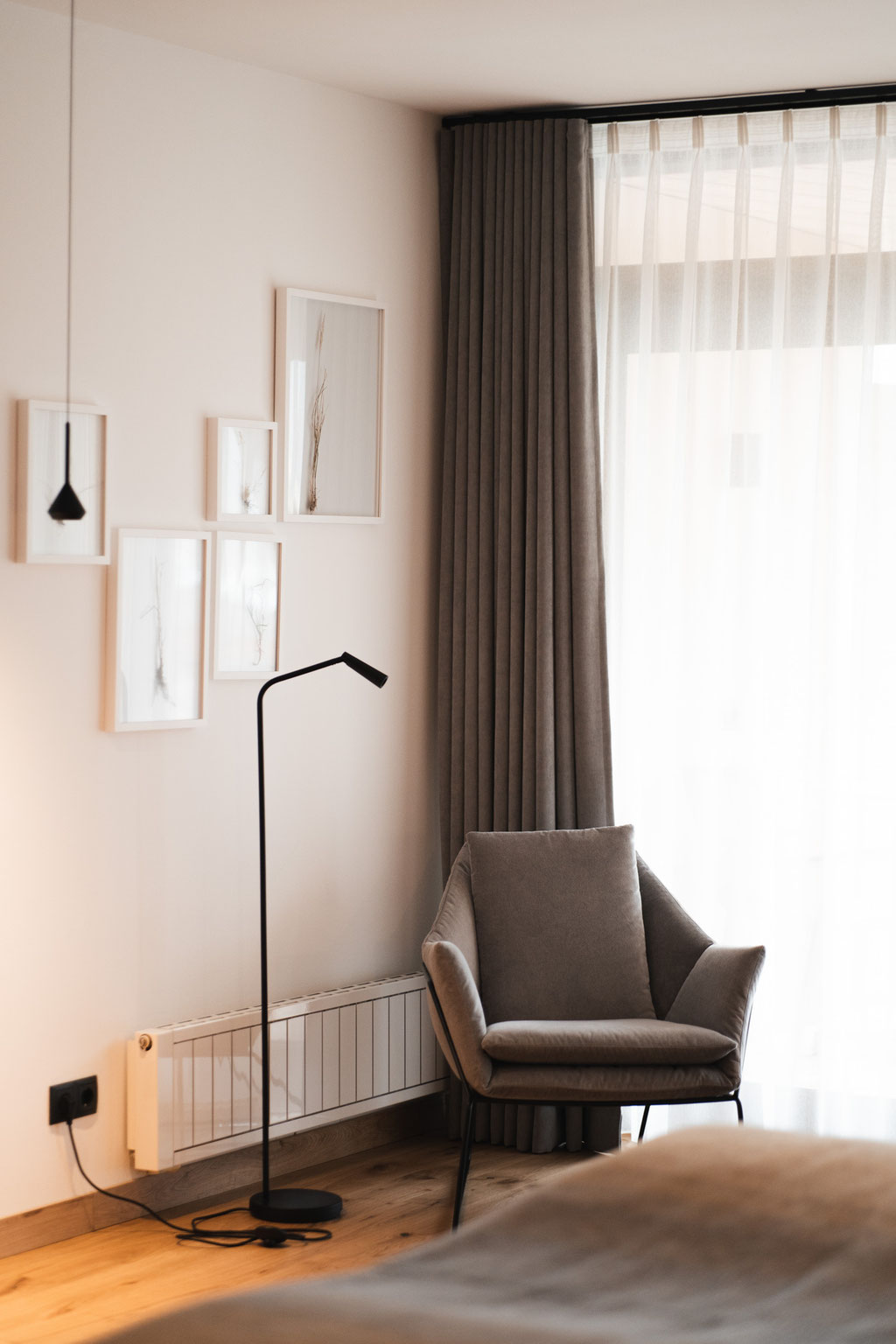 Ruhige Sitzecke im Garberhof mit Sessel, sanften Naturtönen und modernem Design.