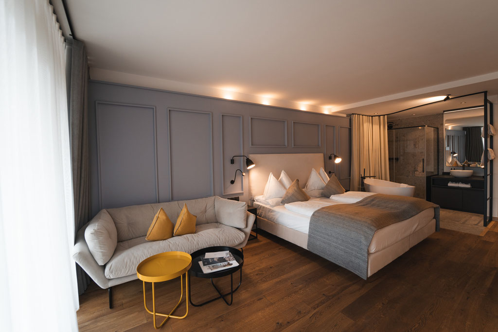 A modern suite at the Garberhof featuring an open-plan living area, a stylish bedroom and an elegant bathroom.