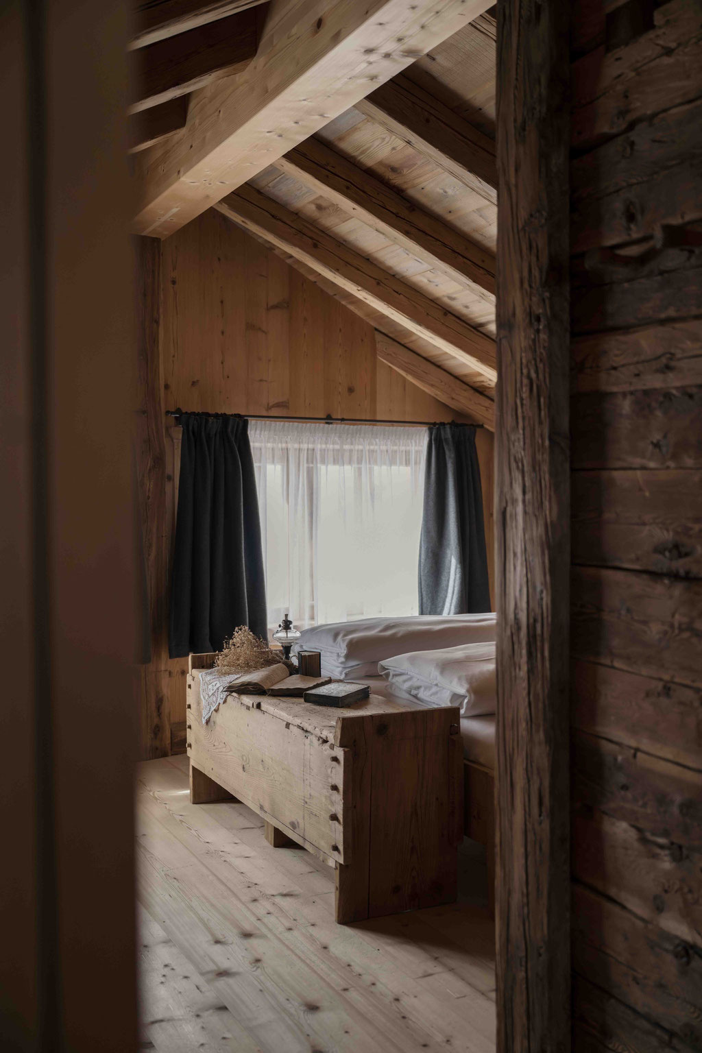 Doppelbett in einem Zimmer mit Holzvertäfelung in der Ciasa Somuer • Member of Mountain Hideaways ©Marika Unterladstätter