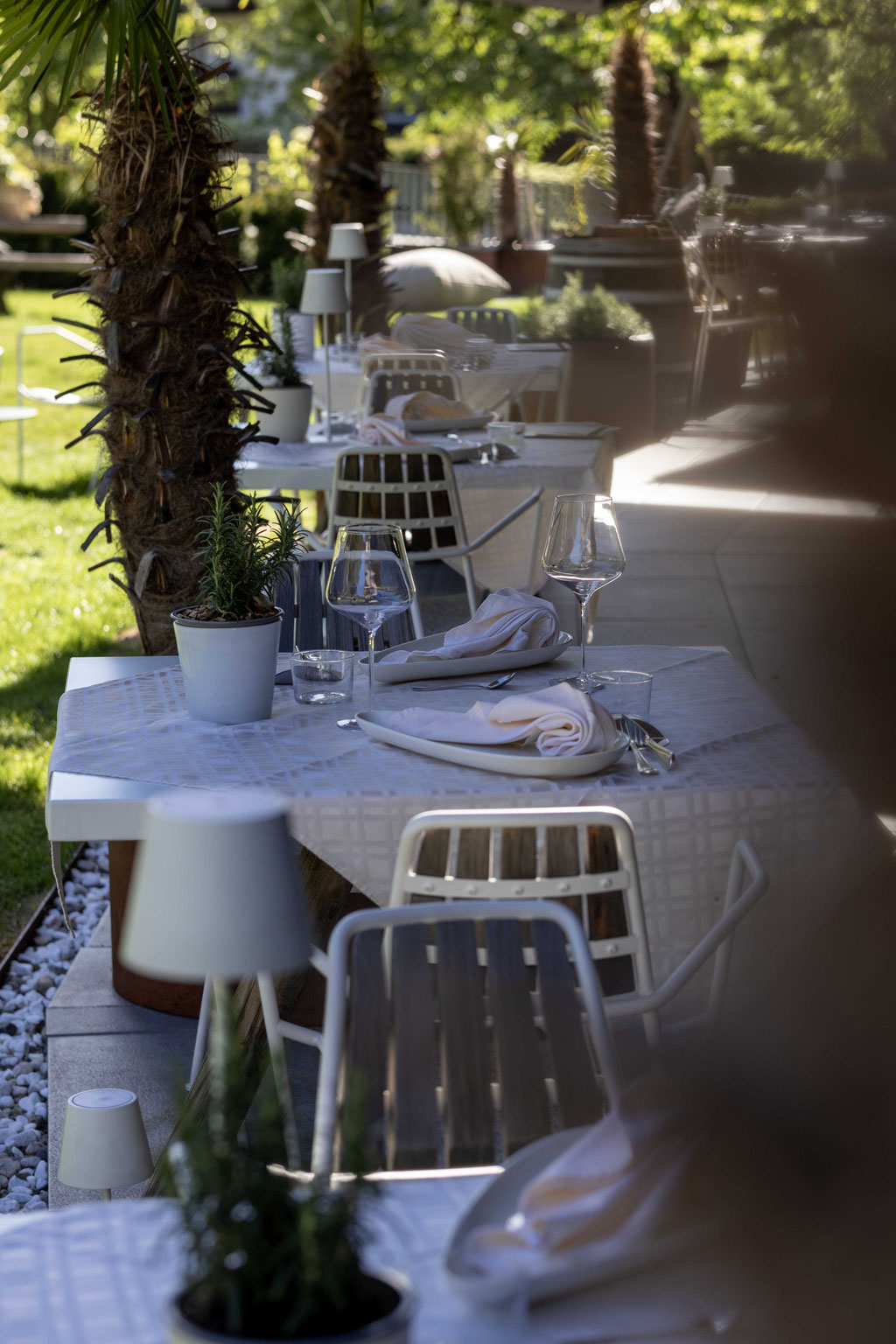 Stilvoll gedeckte Terrasse im Garten des Boutiquehotel PETRUS in Reischach-Bruneck • Südtirol mit eleganten Tischen, viel Grün und entspannter Atmosphäre für genussvolle Momente im Freien.