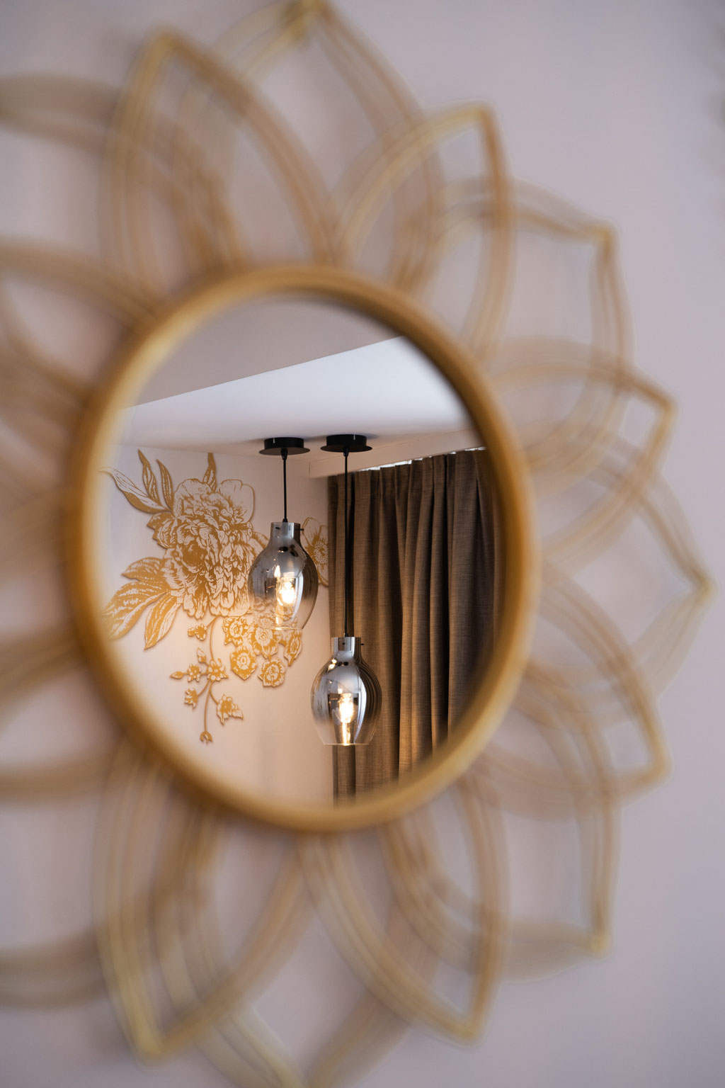 A mirror reflecting the stylish lighting in a room at the Hochkönigin Wellness Hotel in Maria Alm, Salzburg