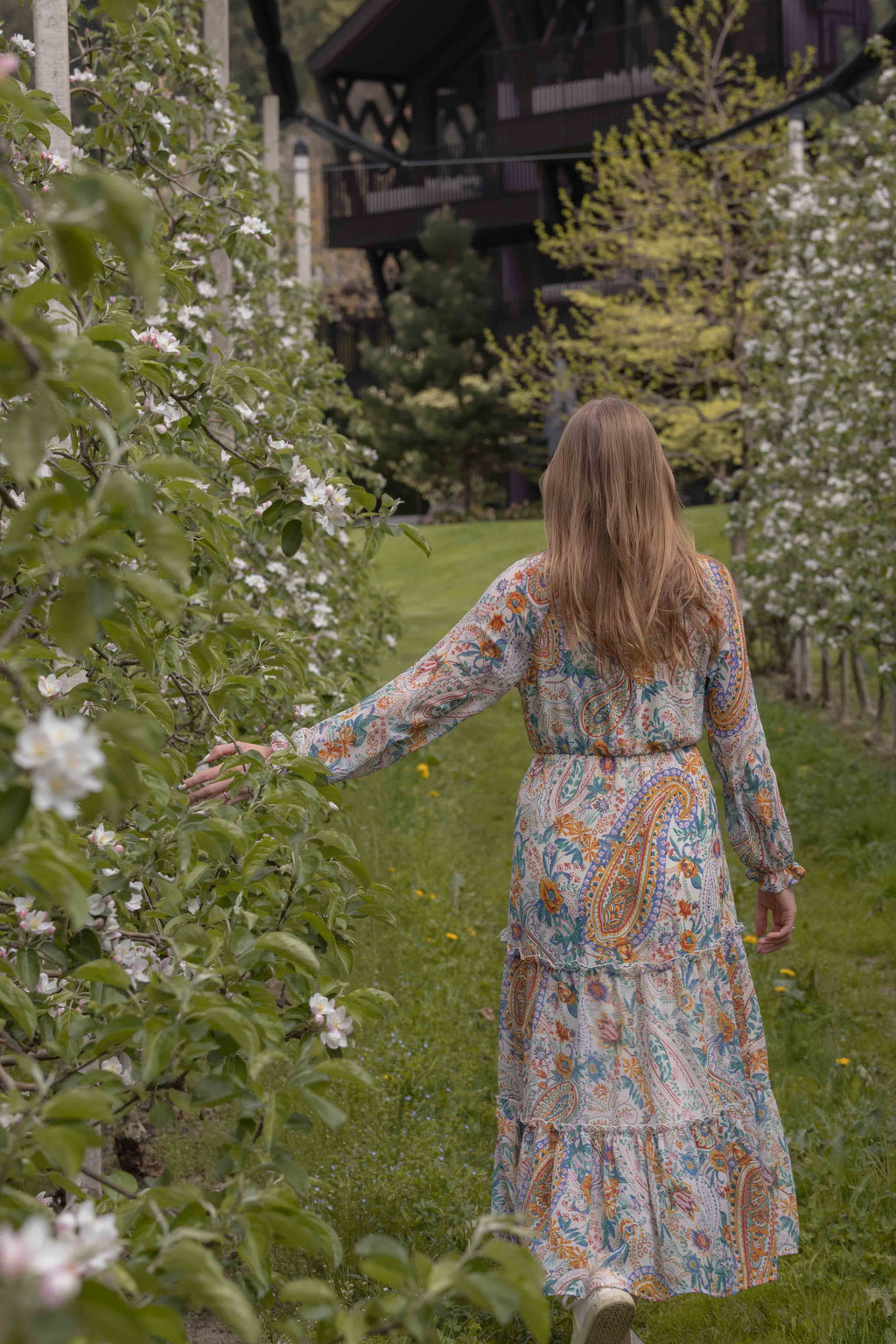 Guests stroll through the blossoming apple trees on the grounds of the Apple Hotel and enjoy the peaceful natural surroundings.