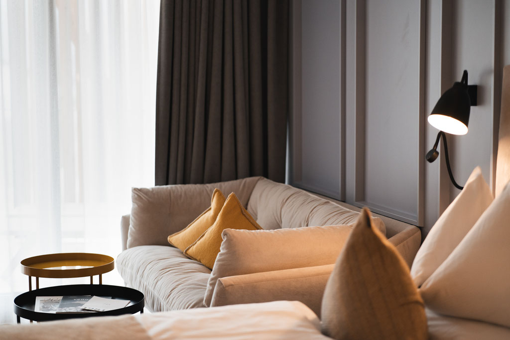 An elegant living area at the Garberhof, featuring a sofa, warm colours and a modern lighting scheme.