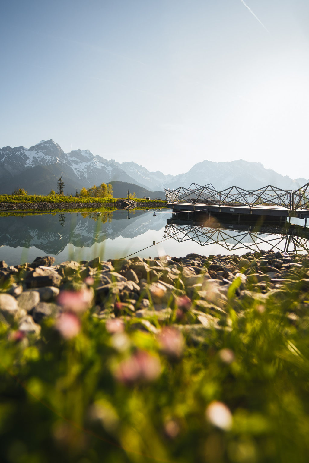 The natural swimming pond at the Hochkönigin Wellness Hotel in Maria Alm, Salzburg, with the Hochkönig massif reflected in its waters