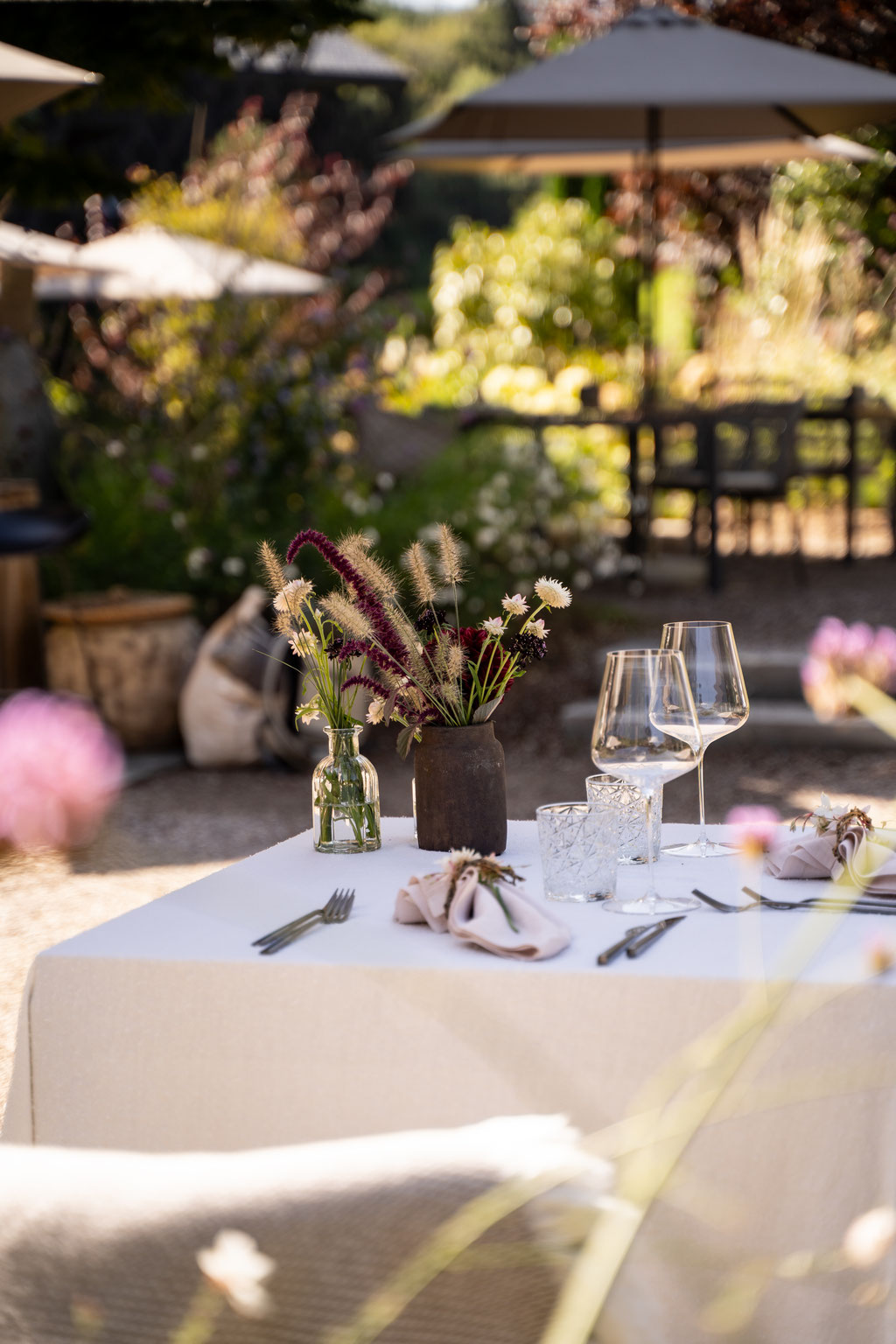 Stilvoll gedeckter Tisch im Garten des Apfelhotels mit floraler Dekoration und sommerlicher Outdoor-Atmosphäre.