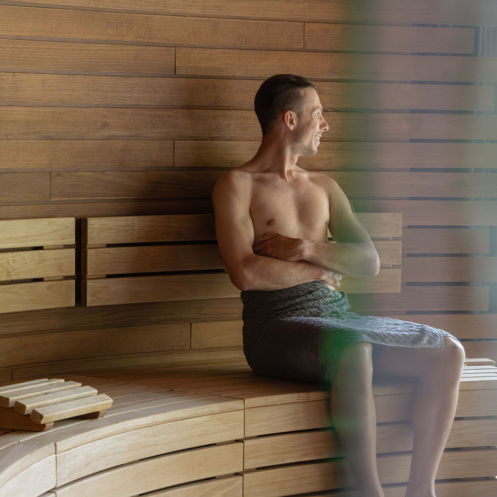 Gast entspannt in der modernen Holzsauna des Apfelhotels und genießt die ruhige Wellness-Atmosphäre.