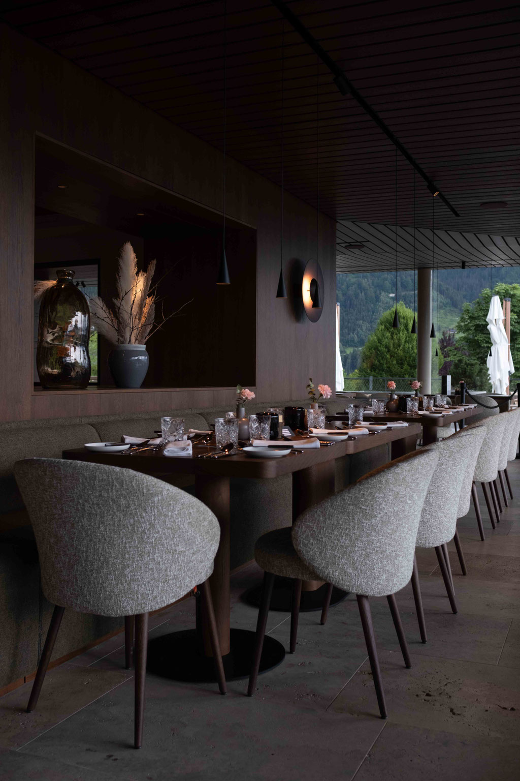 Stylishly set dining area at OBERFORSTHOF combining contemporary design with breathtaking alpine views.