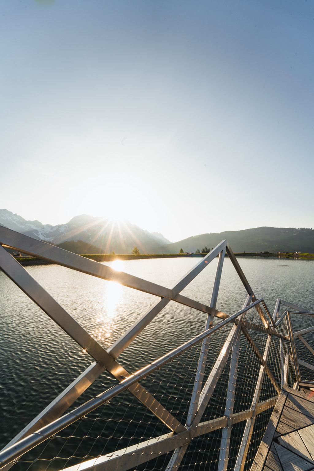 A jetty at the natural swimming pond of the Hochkönigin Wellness Hotel in Maria Alm, Salzburg, at sunrise