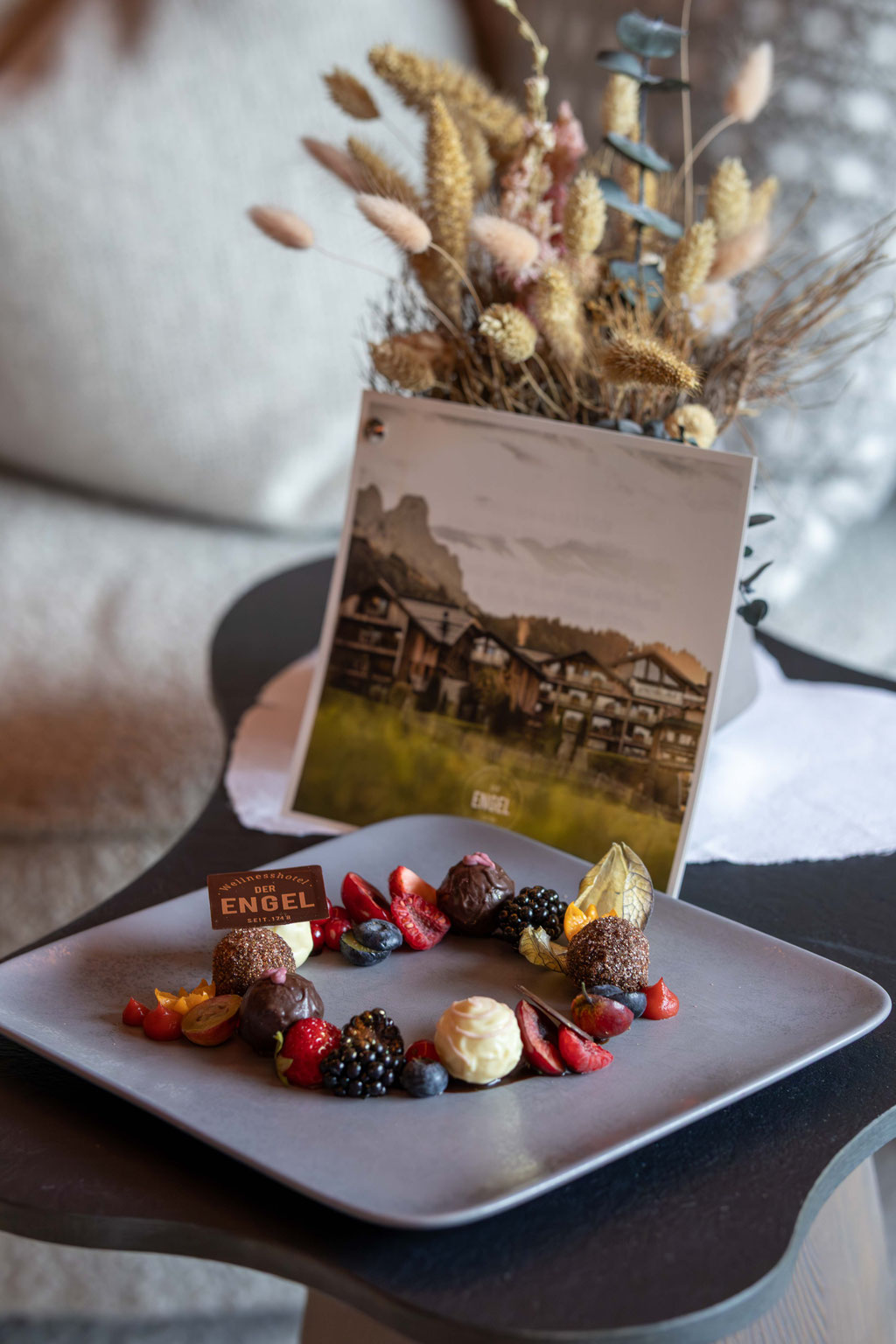Liebevoll angerichtete Pralinen- und Früchtevariation als süße Überraschung im Zimmer des DER ENGEL im Tannheimertal. Frische Beeren, feine Schokoladenspezialitäten und persönliche Details sorgen für einen herzlichen Empfang und genussvolle Wohlfühlmoment