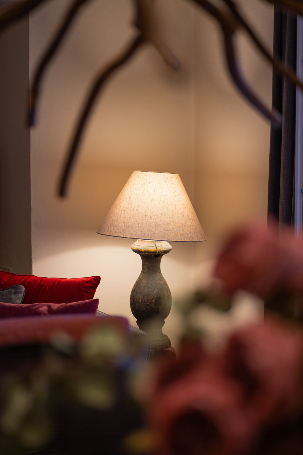 An attractively furnished lounge area with warm lighting, a cosy sofa and decorative touches at the Hotel Mair am Ort Living in Partschins near Merano in South Tyrol, creating a welcoming and relaxed atmosphere.